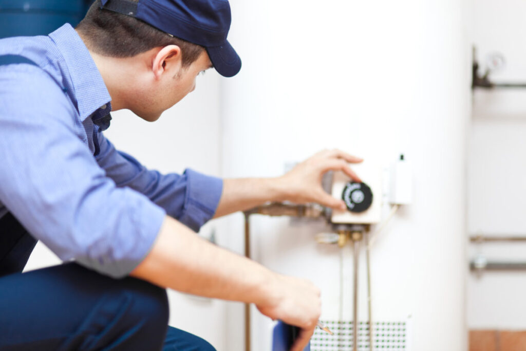 plumber turning temperature knob on water heater