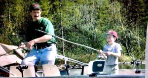 A father and son fishing on a boat
