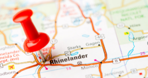A close up of a map with a a red pin marking Rhinelander.