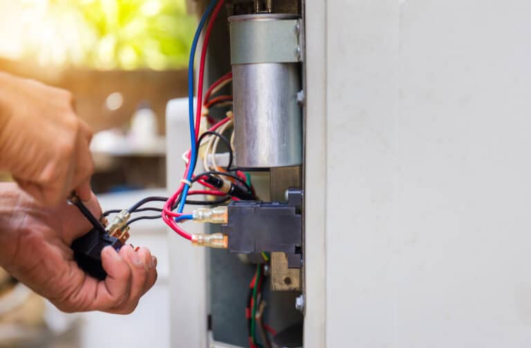 Close up of HVAC repair & repairman fixing heat pump system