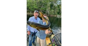 An image of two men and the fish they caught.