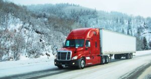 A truck driving through a snowy landscape