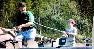 A father and son fishing on a boat
