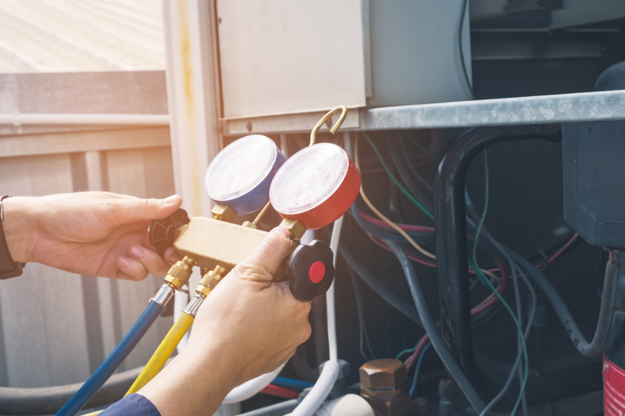 HVAC service gauges connected beside an outdoor unit